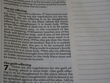 Close-up of open book with text and blank lines.